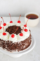Black forest cake, Schwarzwald pie, cherry cake and chocolate with cup of tea. Vegan food, sugar, lactose and gluten free. Vertical orientation.