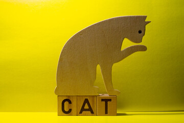 Silhouette of a cat made of plywood on a yellow background
