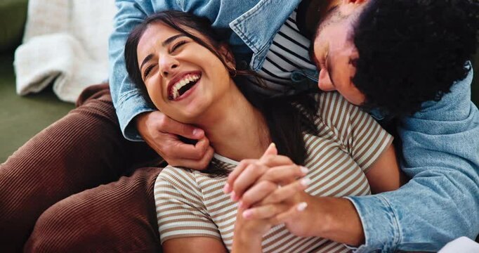 Smile, couple and tickle in home, laugh or bonding together with partner for love. Funny, woman and playful man on sofa to relax for romantic game, connection and holding hands for relationship above