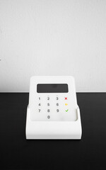 Wireless payment terminal for card or phone transactions on a table.
