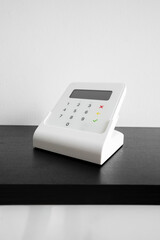 Wireless payment terminal for card or phone transactions on a table.