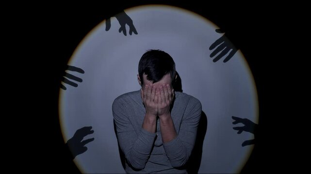 Frightened man surrounded by ghostly reaching arms