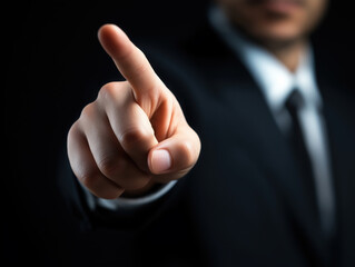Businessman pointing with finger on dark background
