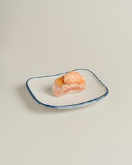 Fresh Gourmet Sushi Piece on Elegant Square Plate with Simple Background