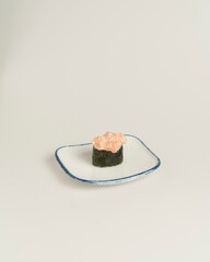 Delicious Sushi Roll with Salmon Topping on Simple White Plate