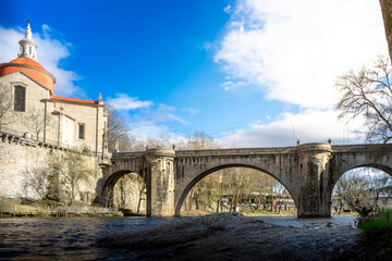 Naklejka premium View at the Sao Goncalo monastery through the Old bridge over the river Tamega in Amarante ,Portugal