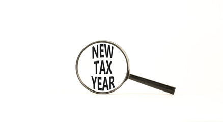 New tax year symbol. Concept words New tax year on beautiful black magnifying glass. Beautiful white background. Business new tax year concept. Copy space.