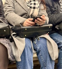 Many passengers are deeply engrossed in their mobile phones while commuting on various forms of...