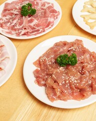 Fresh Sliced Meat and Seasoned Meat on Plates Ready for Cooking