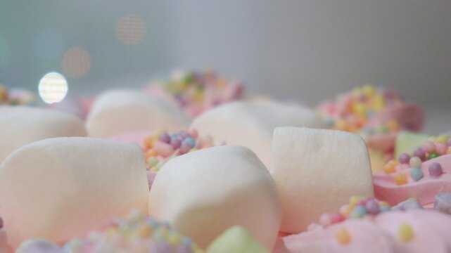 Arranged cream marshmallow cake for festive event. Sweet food, perfect for children's parties. Details of dessert table. Wedding accessories in a soft pink presentation. Decoration wedding party
