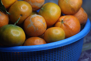 A close-up of fresh oranges in a plastic basket