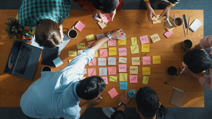 Top down view of smart diverse business people writing marketing idea at meeting and brainstorming...