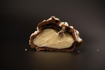 Profiteroles with coconut cream on a black background.
