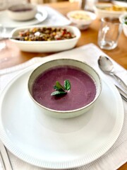 Healthy creamy red cabbage soup topped with herbs