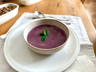 Healthy creamy red cabbage soup topped with herbs