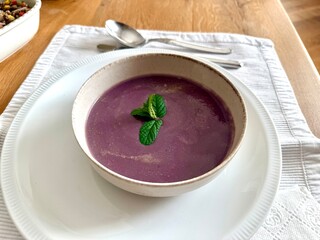 Healthy creamy red cabbage soup topped with herbs