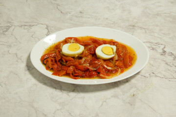 A plate of food with a white plate and a red sauce
