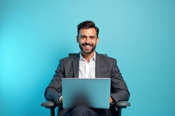 Man is sitting in chair with laptop on his lap