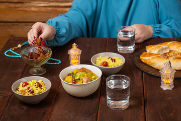 Muslim woman with hand at table eating date iftar Ramadan