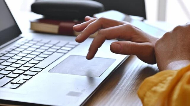 Hands Using Laptop Trackpad: Remote Work and Digital Nomad Lifestyle