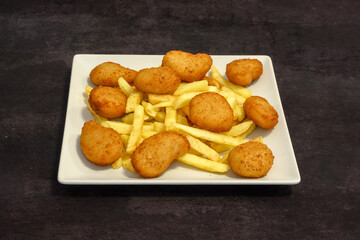 A plate of fried chicken and fried dough balls