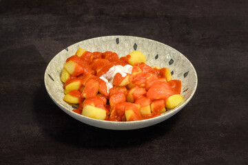 A bowl of food with red sauce and white sauce