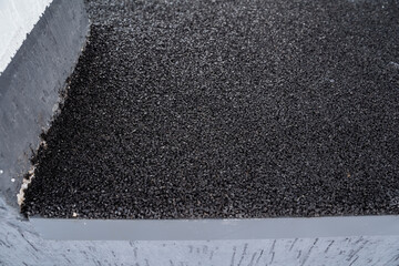 Fototapeta premium This image provides a closeup view of a black bituminous roof surface, showcasing its textured finish and appearance, ideal for construction and rooftop applications