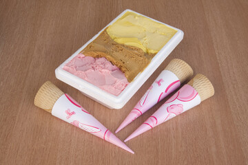 A box of ice cream cones with pink cones
