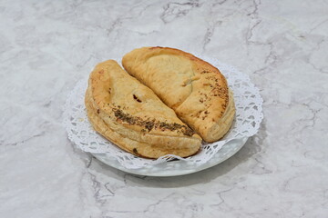 Two pastries on a white plate with a lace doily