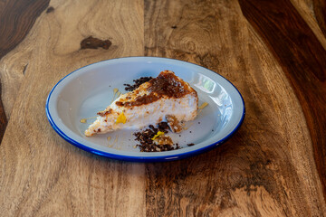 A slice of cake is on a blue plate on a wooden table