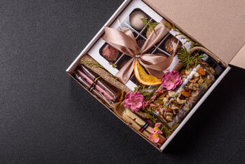 Gift box with a jar of nuts with honey, chocolate and craft candies