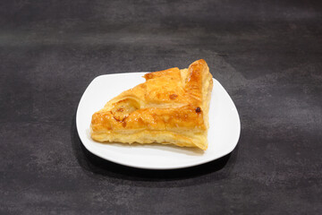 A piece of pastry is sitting on a white plate