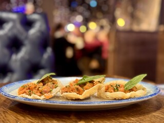 Raw salmon tartare, trout tartare. Delicious raw tuna tartare or sashimi in a white plate on a wooden table in a seafood restaurant. Close-up