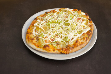 A pizza with lettuce and cheese on top of a white plate
