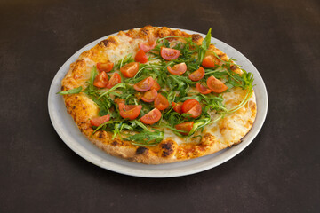 A pizza with tomatoes and spinach on top