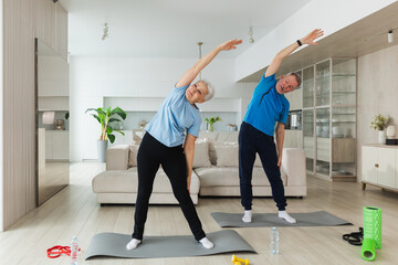 Obraz premium Fitness training. Senior mature healthy fit couple doing sports exercise at home. Mid age husband wife have training workout. Health care healthy lifestyle. Workout rehabilitation for old man woman