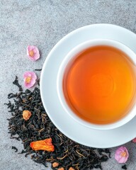 A serene cup of tea surrounded by dried flowers and tea leaves.