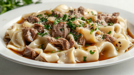 Kazakh national dish beshbarmak with pasta and meat sprinkled with herbs