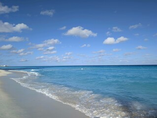 Waves on Caribbean sea with white sand and blue sky, the sea is azure in Mexico