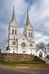 Church of the Sacred Heart of Jesus in Slobodka, Braslav Lakes, Belarus. A white neo-Gothic Catholic church with two tall spires, arched windows, and intricate detailing.