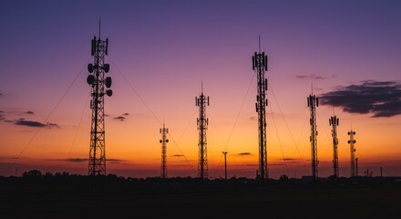 Fototapeta premium Sunset Silhouette of Communication Towers - Five communication towers silhouetted against a vibrant sunset, symbolizing connection, technology, progress, communication, and infrastructure