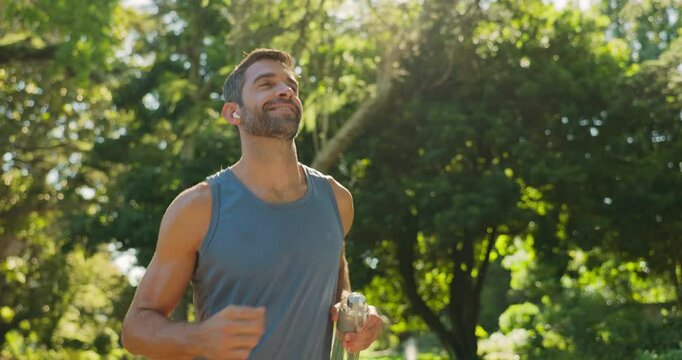 Running, happy and man with earphones, outdoor and routine with music in nature, training or exercise. Active, runner and person with playlist for fitness, workout or practice for marathon in morning