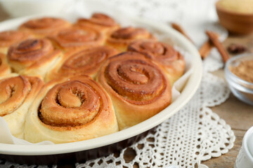 Freshly baked cinnamon rolls on wooden table, closeup