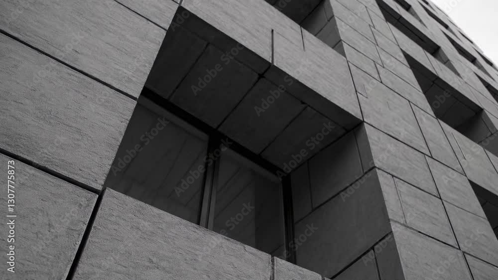 Poster geometric patterns and angular lines define a striking brutalist building facade, showcasing texture