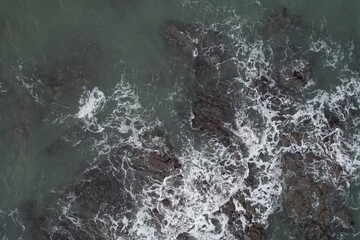 Aerial, Winter’s crashing tidal waves at Down Derry in Cornwall UK