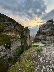 view of monastery on a cliff in metora, greece on the sunset