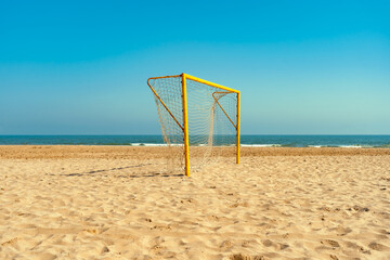 Beach soccer goal, blue sky, summer sport.