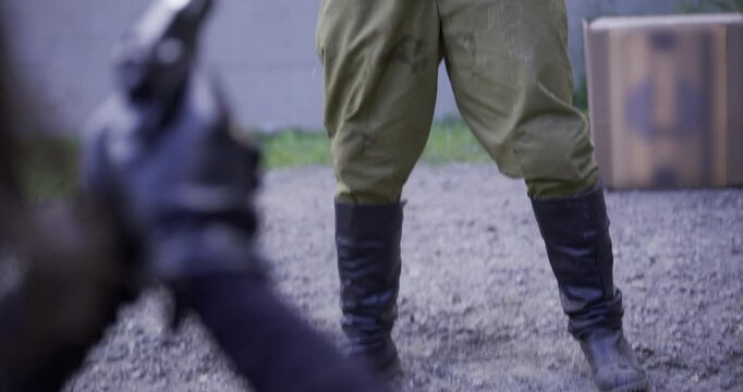 Funny shot of guard peeing his pants in over the top fashion as guy points gun at him