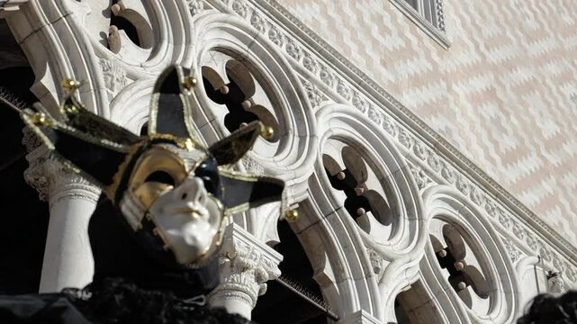 Venice, Italy - People dressed in carnival masks are photographed by tourists in the scenery of the ancient Venetian palaces