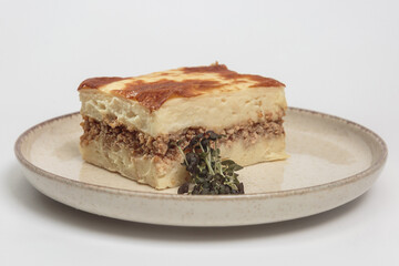 The image shows a slice of moussaka, a classic Greek baked dish. 